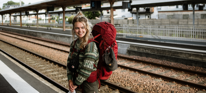 vrouw staat met haar rugzak op het perron